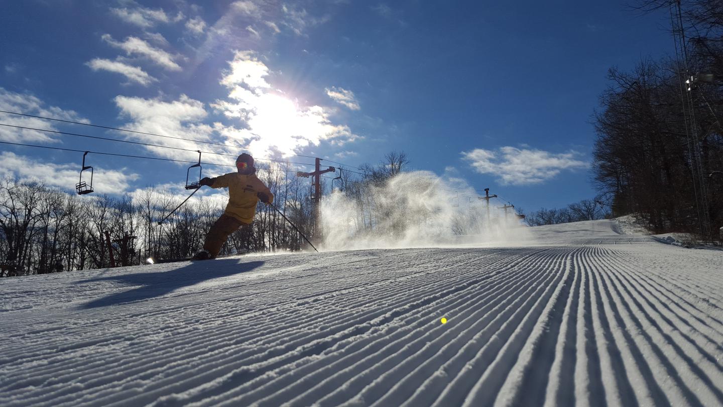 Person skiing down groomed run